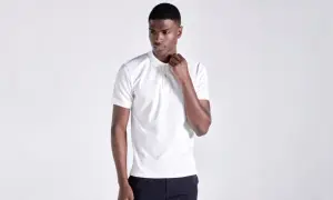 Ein Mann in einem weißen Poloshirt, das klassische Merkmale wie den Kragen und die Knopfleiste zeigt.