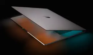 Elegancki MacBook Pro 16 z podświetlaną klawiaturą, otoczony ciepłym i chłodnym światłem, gotowy do pracy.