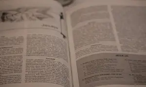 En öppen bibel med texten "Jesaja" synlig. En bok i bibeln som berättar om Guds budskap.