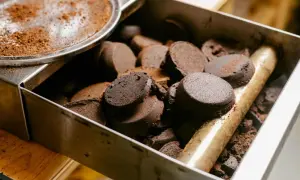 Zwarte, zbite krążki kawy w metalowym pojemniku. Tak powinny wyglądać fusy z ekspresu po zaparzeniu idealnego espresso.
