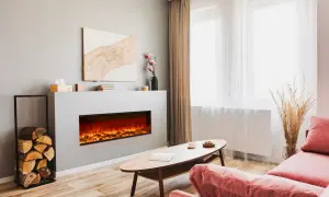 Nowoczesny salon z dużym kominkiem elektrycznym, który tworzy przytulną atmosferę. Obok stos drewna.