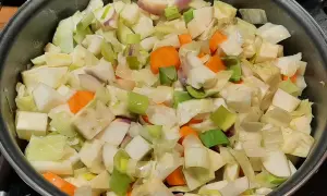 Poêlée de légumes coupés en dés, prêts pour un savoureux bouillon de légume. Carottes, poireaux et navets se mélangent.