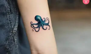 Un pulpo azul vibrante, un ejemplo de tatuaje microrealismo, se posa en un brazo.
