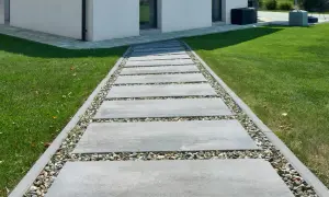 Nowoczesne wykończenie kostki brukowej z kamiennym wypełnieniem tworzy elegancką ścieżkę do domu.