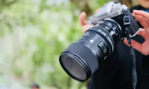 Srebrny aparat fotograficzny dla początkujących z obiektywem Sigma EF-S. Idealny do nauki fotografii.