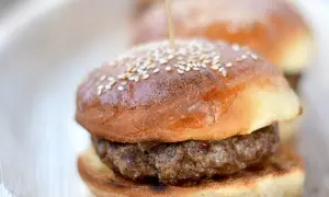 Mini burgery na puszystych bułkach do burgerów, posypane sezamem, gotowe do podania.