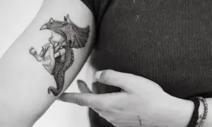 Un tatuaje de un niño con un casco de dinosaurio, con detalles intrincados, que evoca la magia de los tatuajes sevillanos.