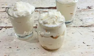 Délicieux tiramisu coco crémeux, servi dans des verrines et un pot en verre, parsemé de copeaux de noix de coco.