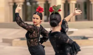 Una sevillana flamenca, con rosa roja en el pelo y pendientes a juego, baila con pasión.