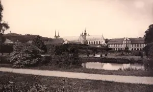 Widok na pałac opatów w Gdańsku z ogrodem i stawem. W oddali wzgórze z pomnikiem.