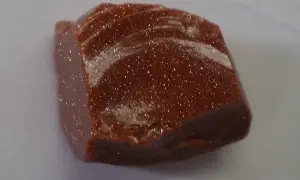 Ein glitzernder goldfluss edelstein mit schimmernden Einschlüssen, der wie ein Sternenhimmel aussieht.