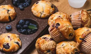 Pyszne muffinki z jagodami, niektóre w foremce, inne ułożone na desce. Ile piec muffinki?