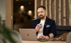 Man med kaffemugg vid laptop, funderar på firmabil regler.