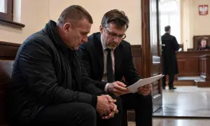 Dwóch mężczyzn w sądzie, jeden w czarnej kurtce, drugi w garniturze, analizuje dokumenty. W tle sędzia i ławnicy. Czy to kolejna recydywa?