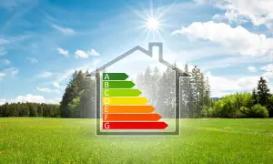 Casa con classe energetica A, simbolo di edilizia sostenibile, immersa in un prato verde sotto un cielo azzurro.