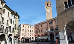 Rynek w Treviso, niedaleko Wenecji, z wieżą zegarową i karuzelą.