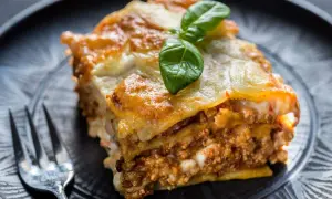Une part de lasagne maison, dorée et gratinée, garnie de viande et de béchamel. Parfaite pour une recette lasagne réussie.