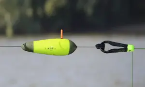 Gelber Wels-Schwimmer mit orangefarbenem Antennenstift und schwarzem Clip an einer Angelschnur.