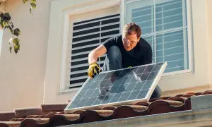 Hombre instala panel solar en tejado. ¡Qué frustración que mi comunidad no me deja poner placas solares!