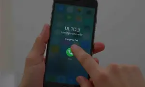 Dłoń naciska przycisk "Emergency Call" na ekranie telefonu. To może być pomocne, jak odblokować telefon zablokowany przez operatora Plus.