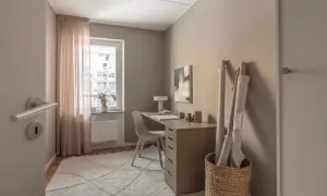 En ljus och inspirerande arbetsplats kontor med skrivbord, stol, textilier och konst.