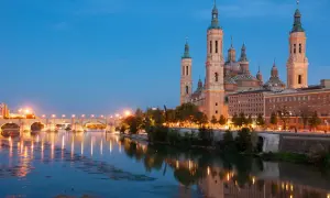 Bazylika w Saragossie i most nad rzeką Ebro o zmierzchu. Idealne miejsce na tanie hiszpania loty.