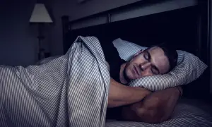 Man sleeping soundly, embracing deep sleep for optimal muscle recovery.