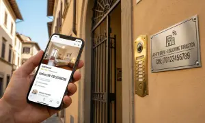 Smartphone mostra un appartamento per affitti brevi. La targa sul muro indica "Affitti Brevi - Locazione Turistica" e il codice CIN, facilitando la comunicazione condominio.