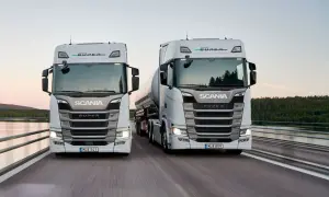 Två nya Scania lastbilar, en med tank, kör på en bro. Kolla in ny Scania lastbil pris för din nästa transport.