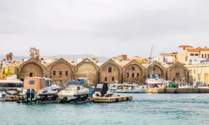 Port w Chanii na Krecie zimą. Łodzie zacumowane przy kamiennych budynkach weneckich.