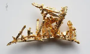Złoto próba 525, krystaliczna struktura przypominająca miniaturowy, lśniący krajobraz.