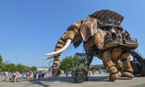 Le Grand Éléphant mécanique se promène sur l'île de Nantes, transportant des visiteurs émerveillés dans sa structure en bois.