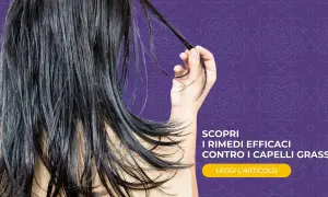 Capelli lunghi e scuri, che sembrano un po' appesantiti, con una mano che ne raccoglie una ciocca. Scopri rimedi efficaci contro i capelli grassi.