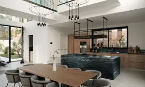 Nowoczesna kuchnia z salonem, inspiracje dla otwartej przestrzeni. Czarna wyspa kuchenna, drewniane fronty, designerskie oświetlenie.