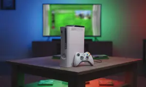 Biały Xbox 360 z kontrolerem na stoliku, przypominający czasy, kiedy wyszedł.