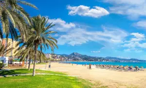 Malaga plaże: palmy, złoty piasek, turkusowe morze i góry w tle. Idealne miejsce na relaks.