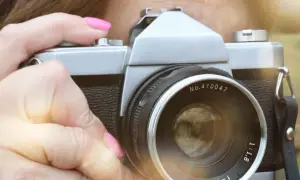 Dłoń z różowym lakierem trzyma aparat, gotowa do uchwycenia tego, czego nie można fotografować w Polsce.
