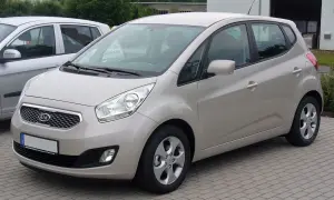 Jasny beżowy Kia Venga 1.4 benzyna stoi na kostce brukowej.
