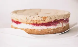 Himbeertorte rezept: Ein Biskuitboden mit Himbeermarmelade und Sahne, bereit zum Verzieren.