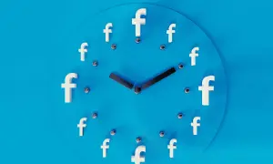 Zegar z literami "f" zamiast cyfr symbolizuje planowanie postów na FB. Czas na publikację!