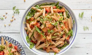 Pasta fredda con salmone affumicato, pomodorini, rucola e olive nere. Un piatto estivo leggero e gustoso.
