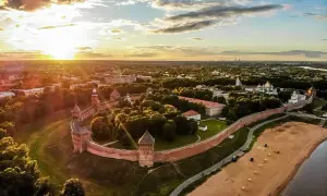 Solnedgång över Novgorod, en historisk stad med en imponerande kreml. Denna vy liknar en gammal **Novgorod karta** med sina befästningar och gyllene kupoler.