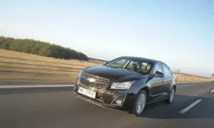 Brązowy Chevrolet Cruze 1.8 benzyna jedzie autostradą.