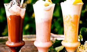 Tre läckra milkshakes i glas med grädde och strössel. Perfekt för ett somrigt milkshake recept!