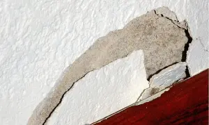 Odkruszający się tynk wewnętrzny, odsłaniający beton. Dowiedz się, jak naprawić odpadający tynk wewnętrzny.