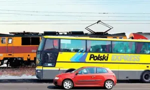 Pociąg, żółty autobus "Polski Express" i czerwony samochód jadą obok siebie, jakby na trasie katowice-kraków.