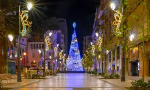 Ulica ozdobiona świątecznymi iluminacjami, z ogromną choinką na końcu. Idealne miejsce na sylwestra, szukaj tanich lotów na Sylwestra!