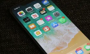 Ekran iPhone'a z ikonami aplikacji. Dowiedz się, jak zmniejszyć czułość ekranu dotykowego, aby uniknąć przypadkowych dotknięć.