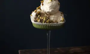 Krämig pistageglass i ett elegant glas, toppad med krossade pistagenötter. Ett perfekt pistageglass recept för en lyxig dessert.