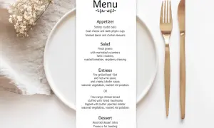 Menu weselne z daniami, talerzem i złotymi sztućcami.